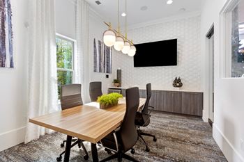 A conference room with a long table and chairs.